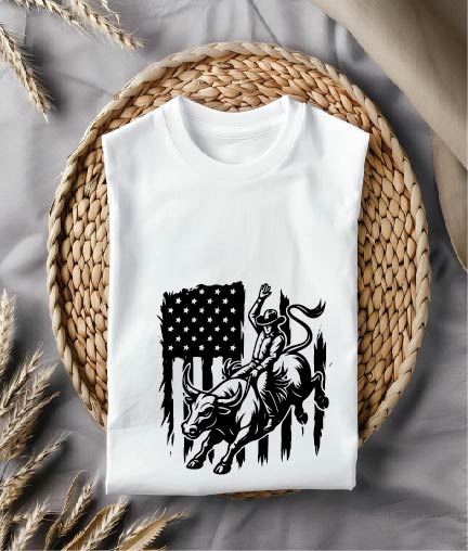 White t-shirt with a graphic design of a bull rider and American flag on a woven mat.