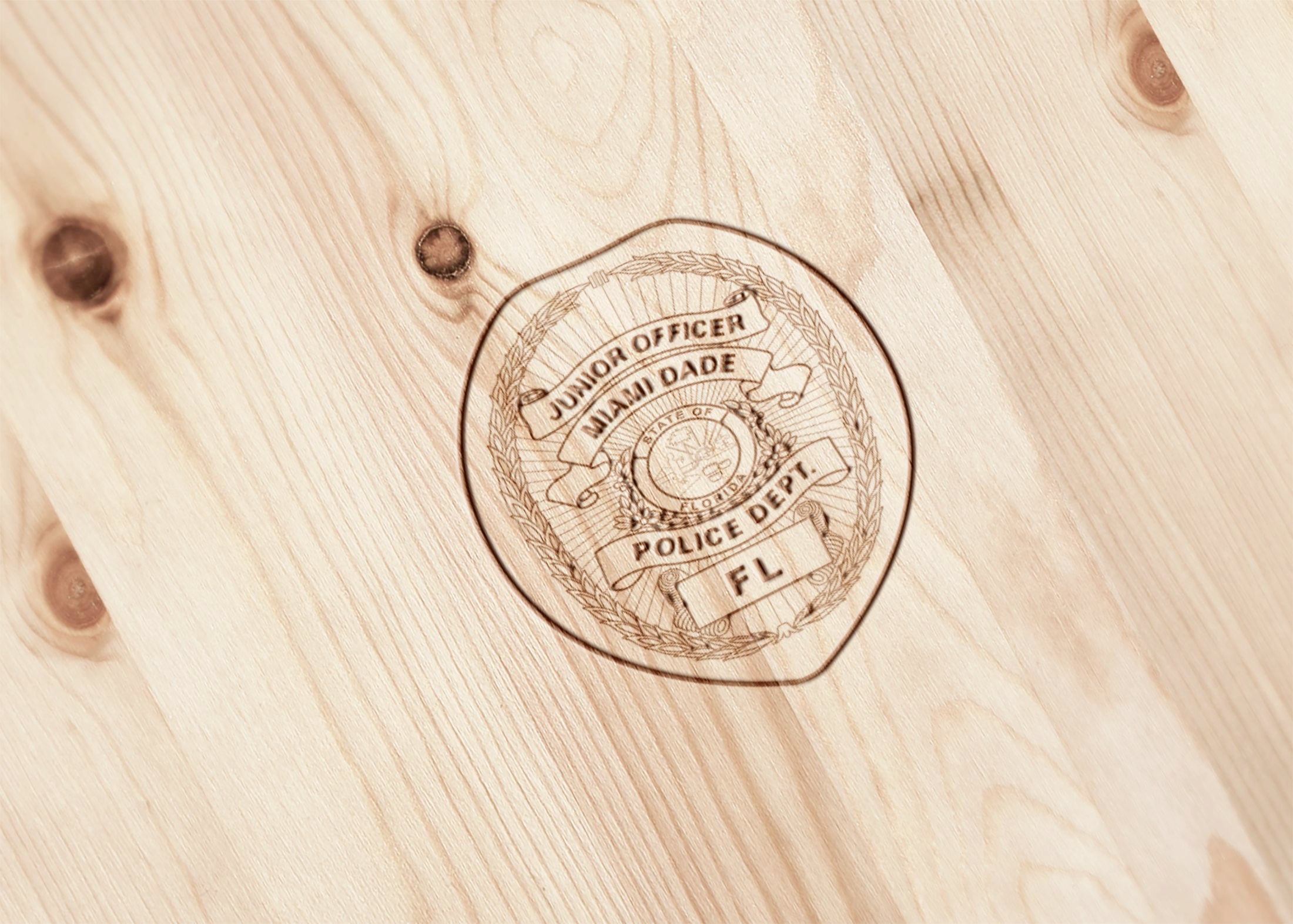 Engraved police badge on a wooden surface.
florida police badge engrave
logo engraving on a wood